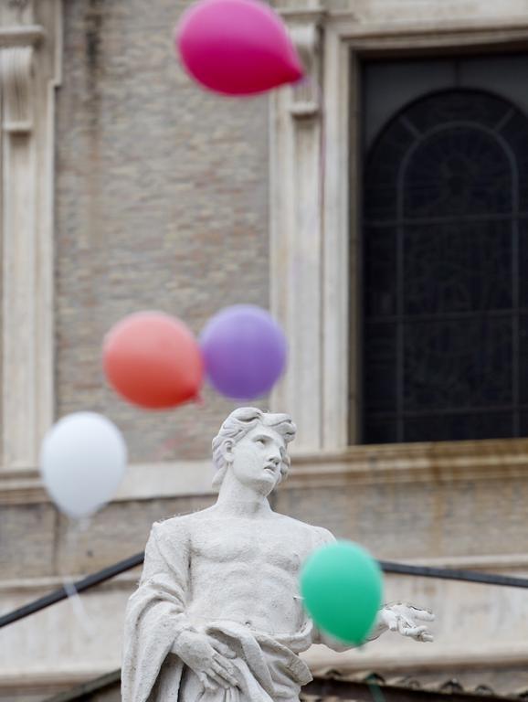Colored balloons released by children fly next to a statue, at the end of the noon Angelus prayer recited by Pope Francis in St. Peter's Square at the Vatican, Sunday, Jan. 25, 2015. (AP Photo/Gregorio Borgia)